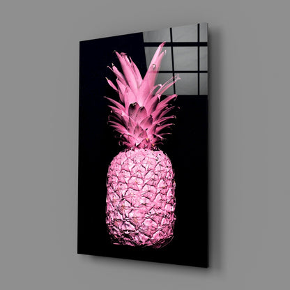 Pink pineapple illustration on black glass panel mounted on gray wall, angled perspective view.