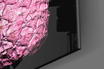 Close-up of pink textured glass wall art with dimensional carved surface details, mounted on gray wall interior.