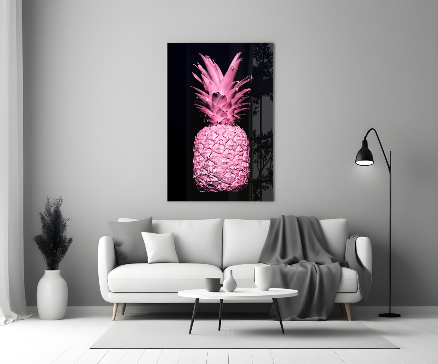 Pink pineapple glass wall art displayed above white sofa in minimalist monochrome living room setting.