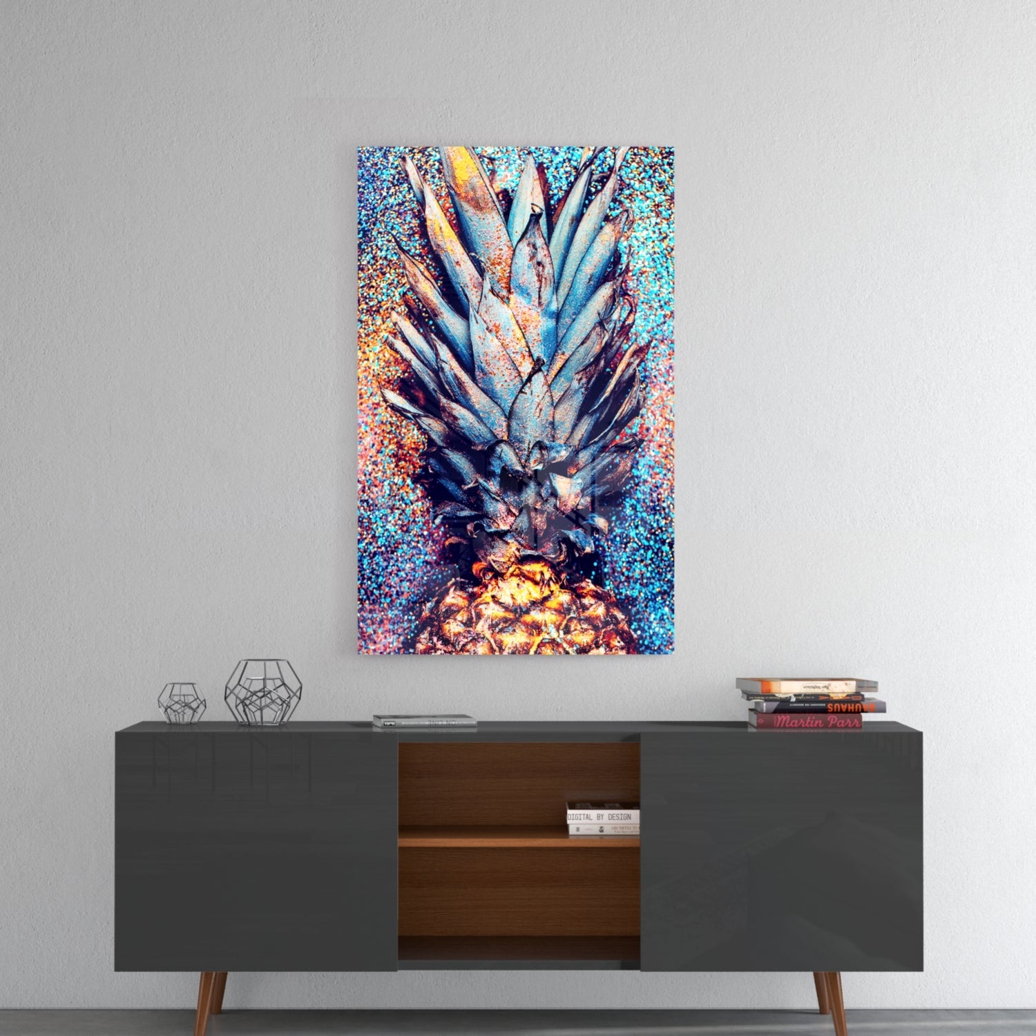 Colorful glass pineapple art hanging above modern mid-century console table with geometric decor and books.