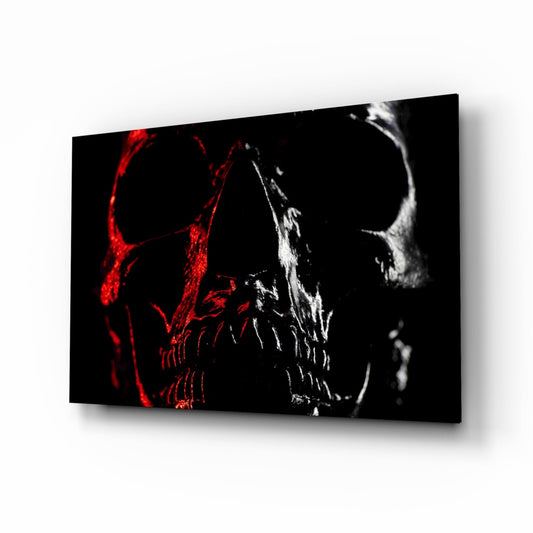 Angled perspective of glass wall art displaying red and white neon-style skulls against black background.