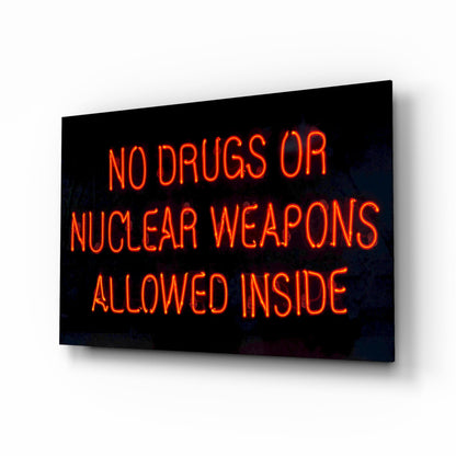 Neon glass wall art displaying red glowing text reading "NO DRUGS OR NUCLEAR WEAPONS ALLOWED INSIDE" against black background, angled perspective view.