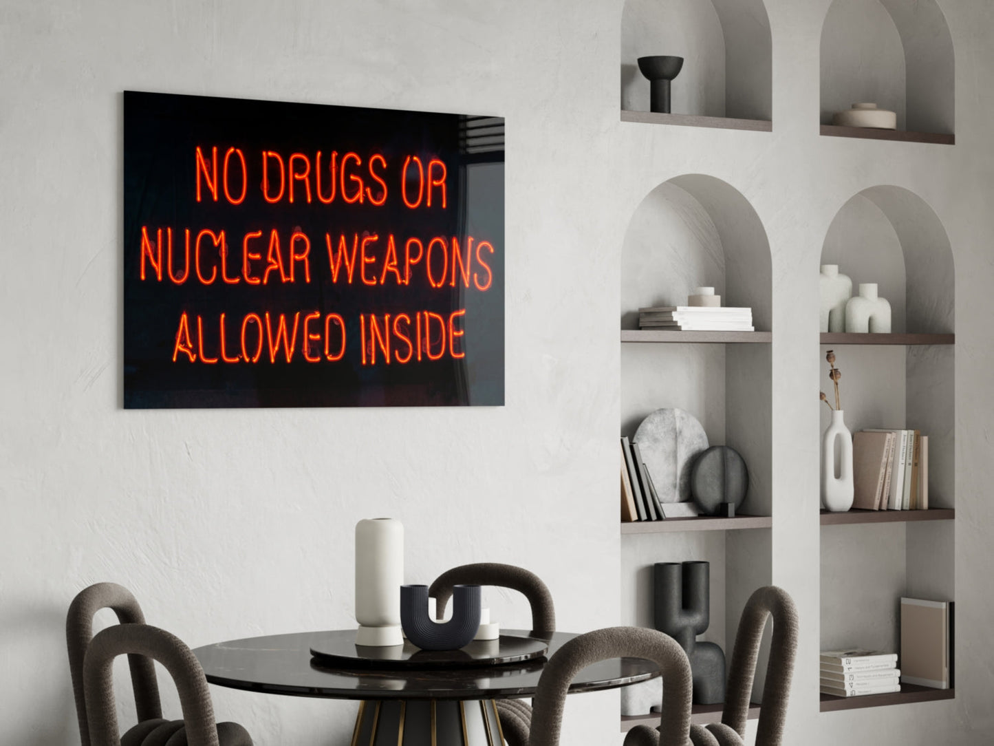 Neon glass wall art displaying "NO DRUGS OR NUCLEAR WEAPONS ALLOWED INSIDE" in orange text above a dining table.