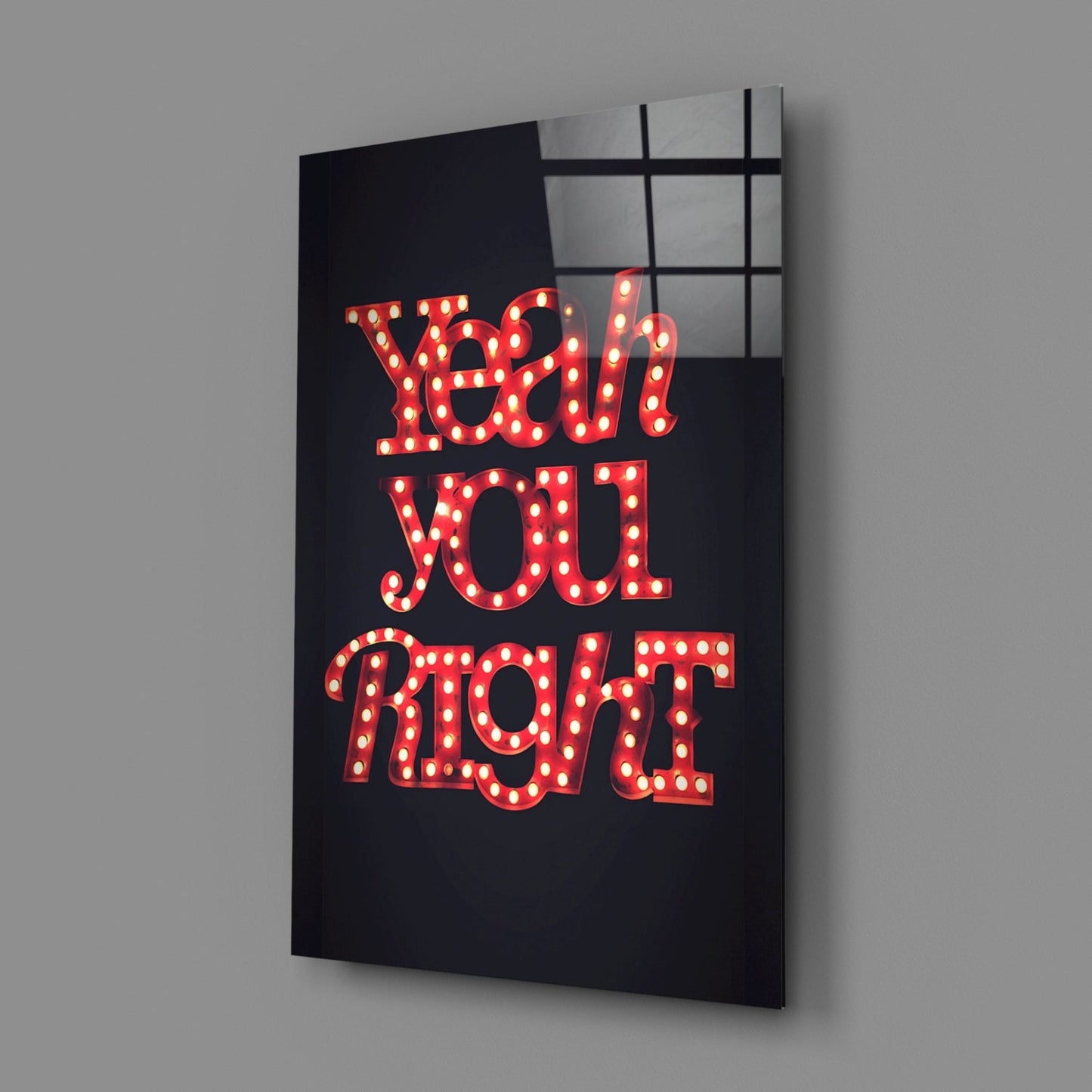 Red illuminated marquee-style lettering spelling "Yeah You Right" on black glass wall art, angled view showing grid pattern window reflection.