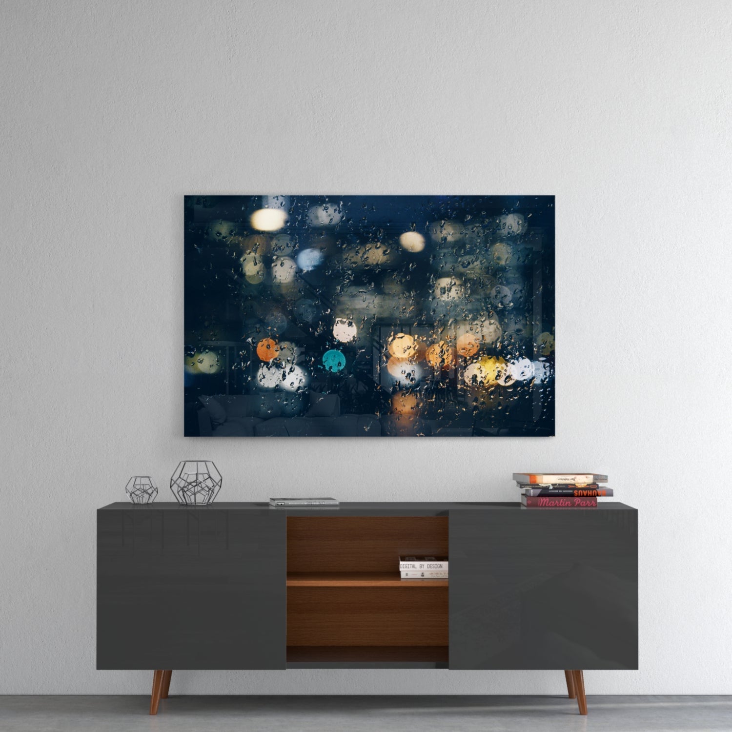 Rain-covered window with blurred city lights in orange, blue, and yellow tones displayed above a mid-century modern console table.