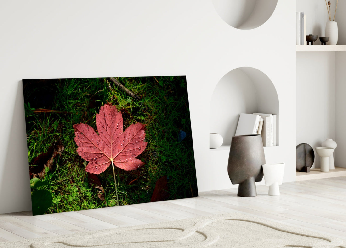 Pink Leaf Glass Wall Art leaning against white wall in minimalist interior with decorative objects and niches.