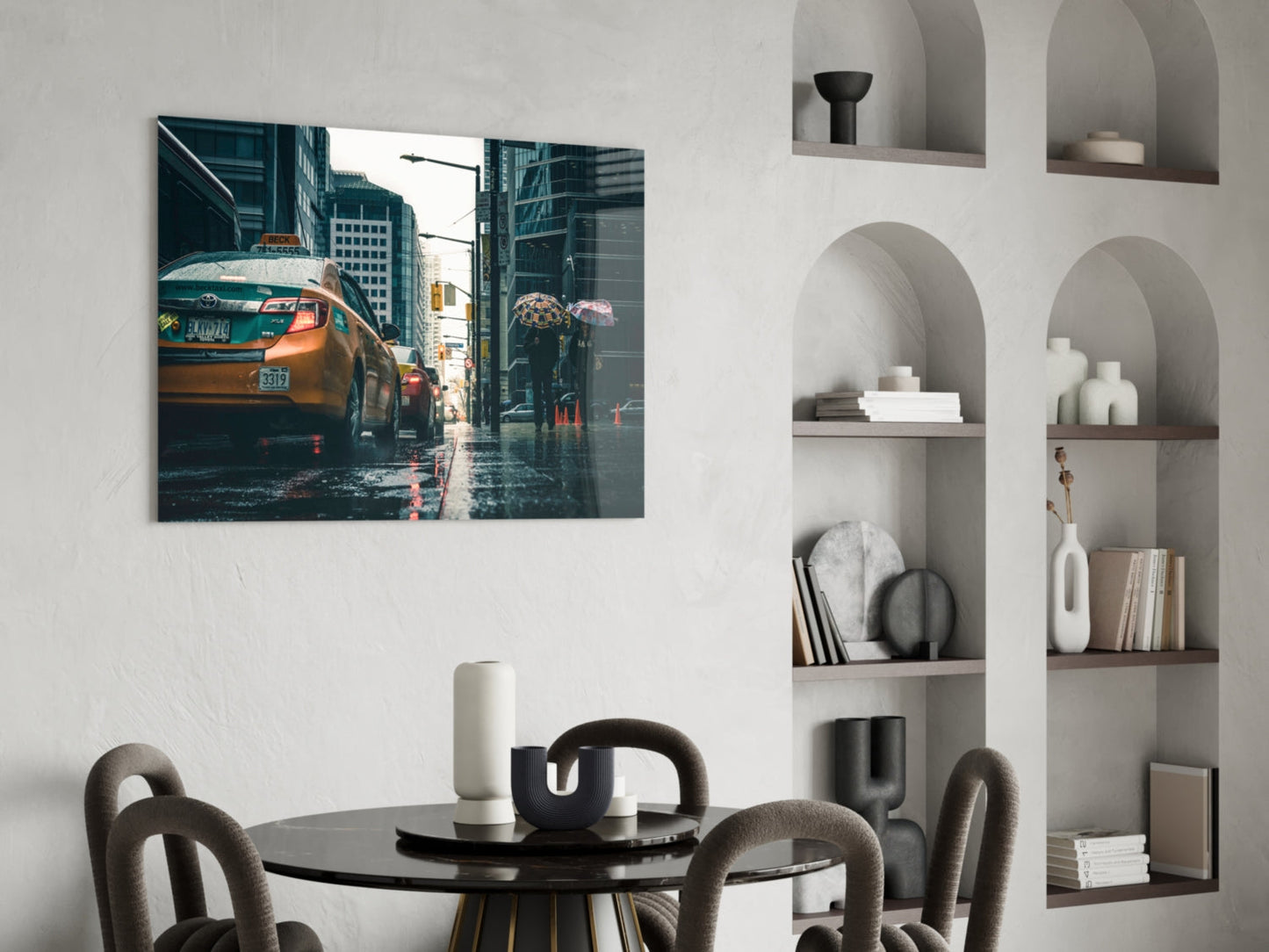 Glass wall art depicting a wet city street with yellow taxi cabs and tall buildings, displayed above a black dining table.