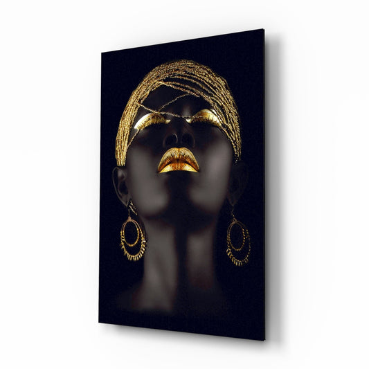 Portrait of a dark-skinned woman in profile wearing gold beaded headwrap and matching lip and ear jewelry against black background on glass panel.