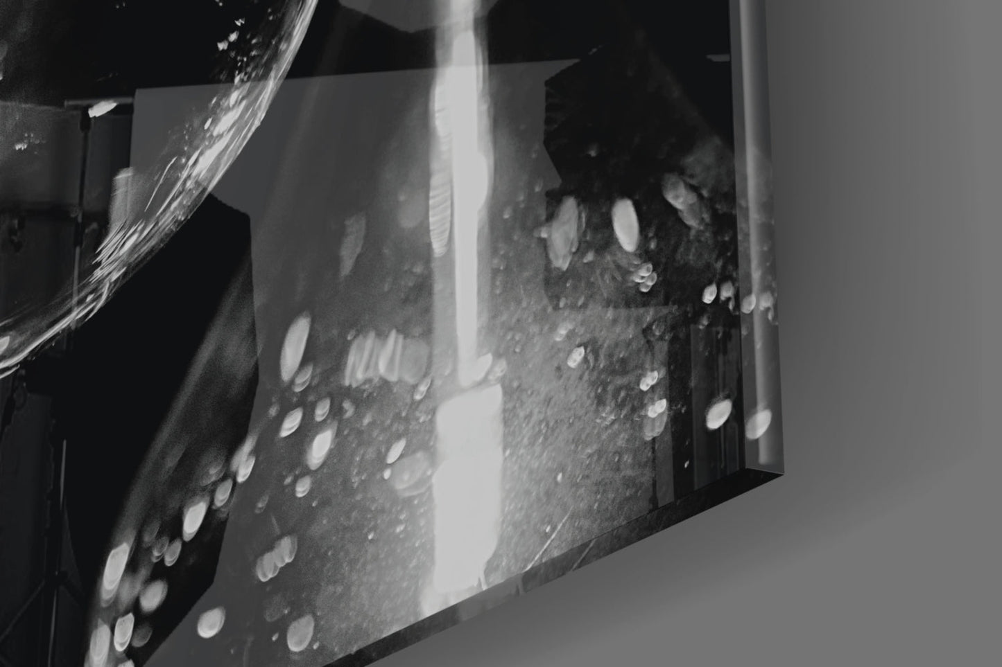 Close-up detail of etched glass wall art with circular patterns and bright light reflecting through frosted surface.