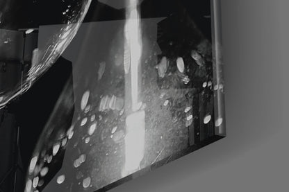 Close-up detail of etched glass wall art with circular patterns and bright light reflecting through frosted surface.