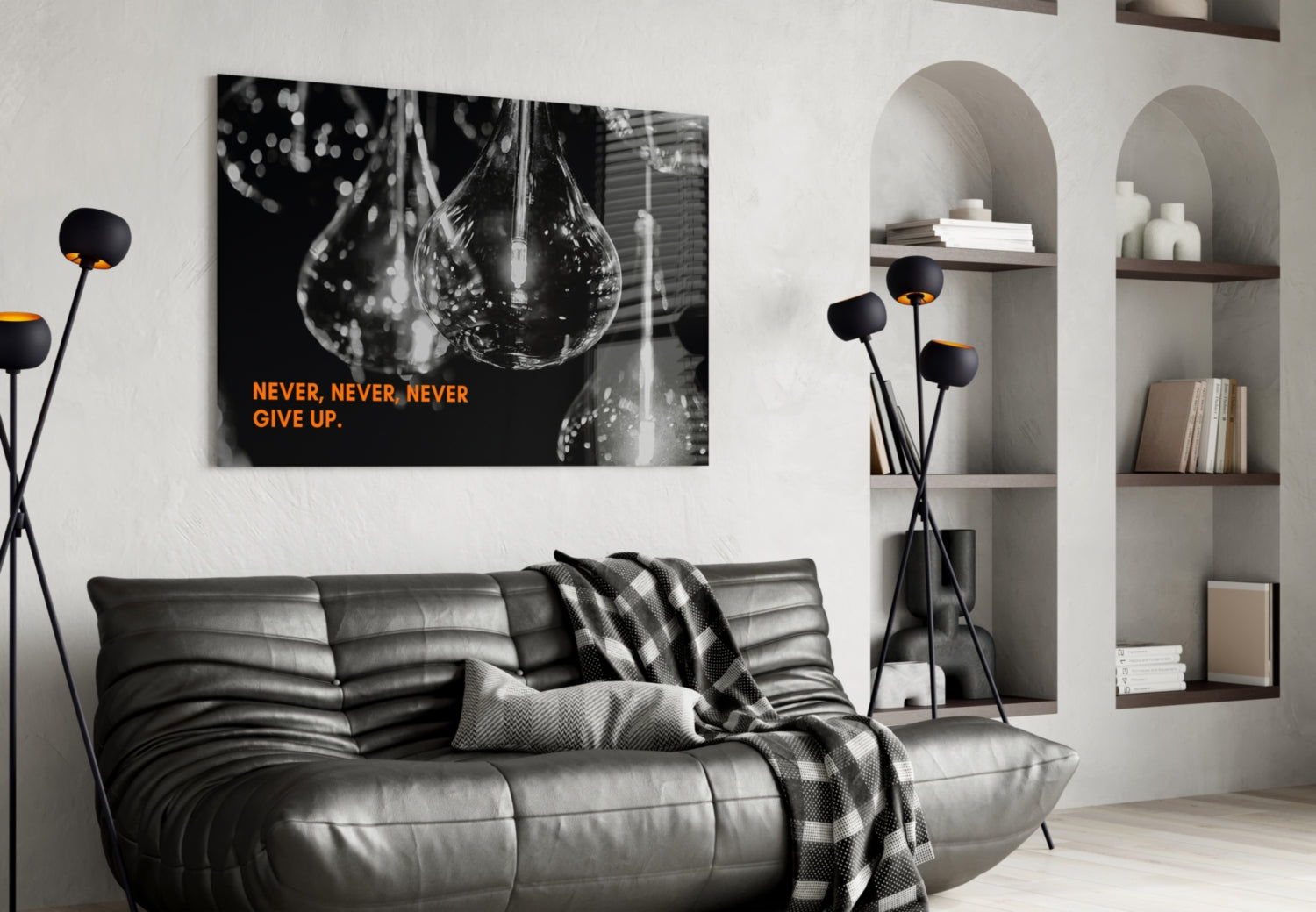 Black and white motivational canvas with orange "Never, Never, Never Give Up" text displayed above gray leather sofa in modern living room.