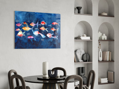Colorful fish glass wall art in vibrant reds, oranges, and yellows displayed above a black dining table with gray chairs in a modern interior.