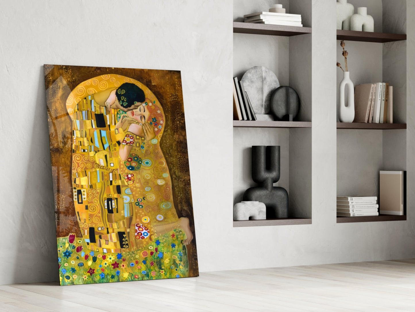 Klimt's golden "The Kiss" glass art leaning against white wall beside modern shelving with decorative objects.
