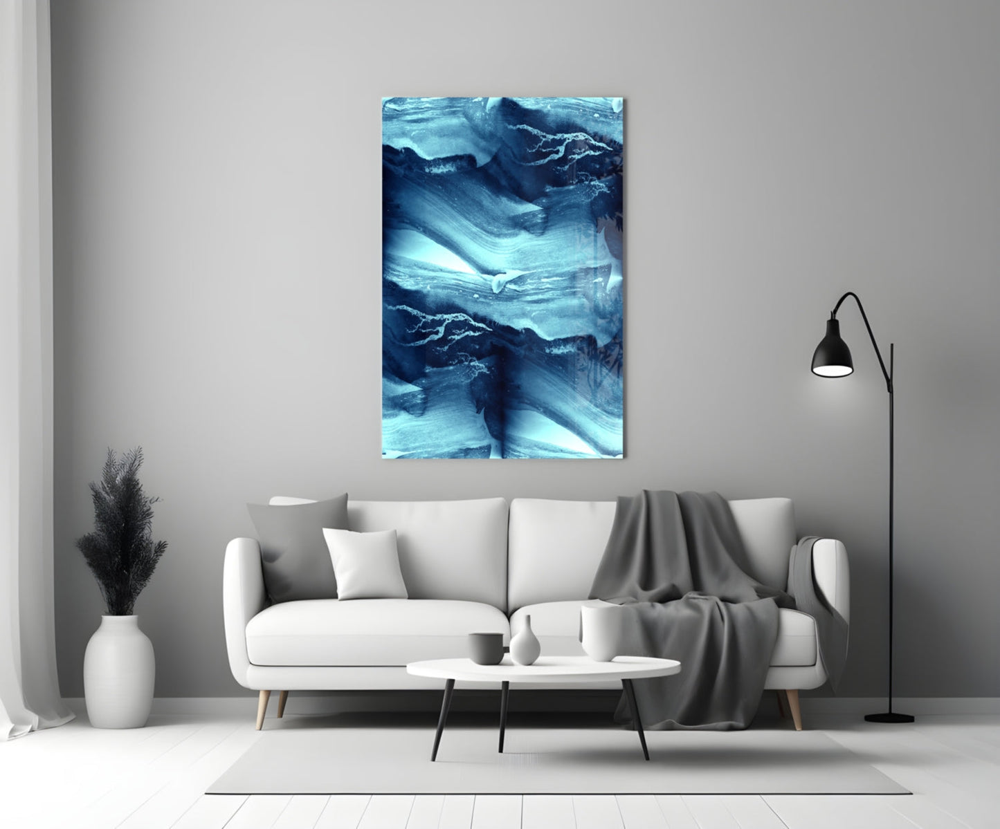 Blue Serenity Glass Wall Art displayed above a white sofa in a minimalist living room setting with neutral décor.