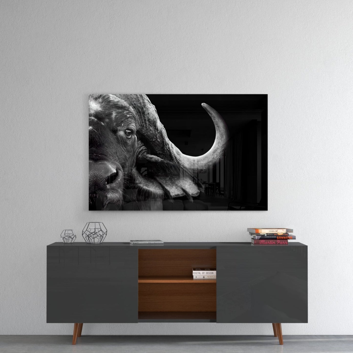 Black and white glass wall art of a buffalo head with curved horns displayed above a mid-century modern console table.
