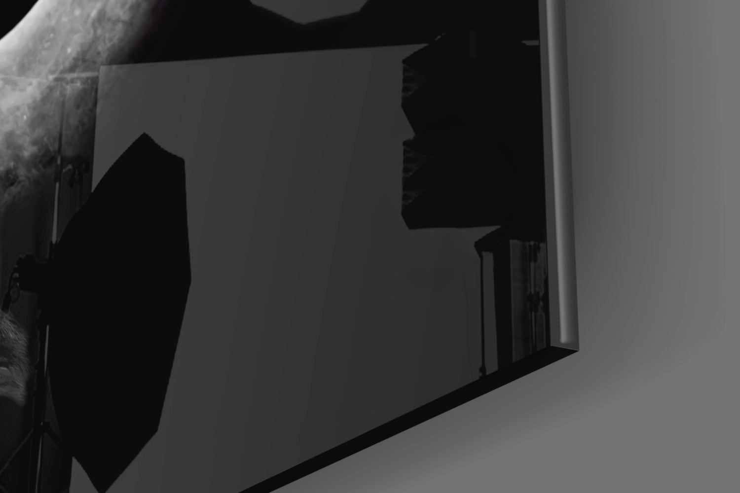 Black and white architectural photograph showing silhouetted glass wall art panel mounted on light interior wall with staircase visible behind.