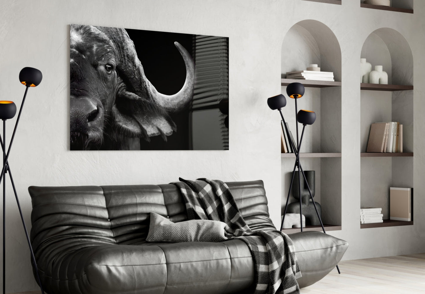 Black and white bison head glass wall art displayed above a gray leather sofa in a modern living room interior.