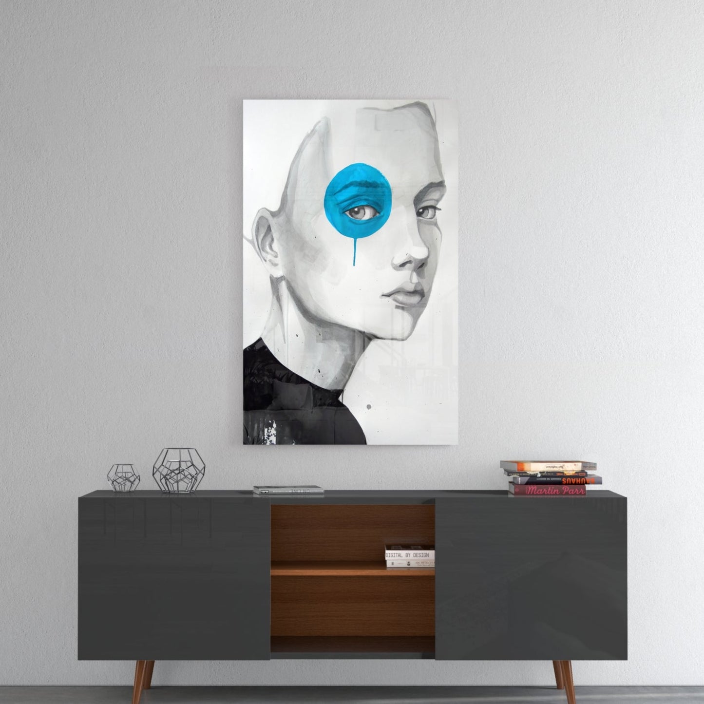 Modern wall art displaying a monochrome portrait with striking blue circular element covering one eye, displayed above mid-century sideboard.