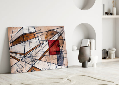 Abstract glass wall art with geometric lines, brown tones, red rectangle, and handwritten text leaning against white wall beside decorative objects.