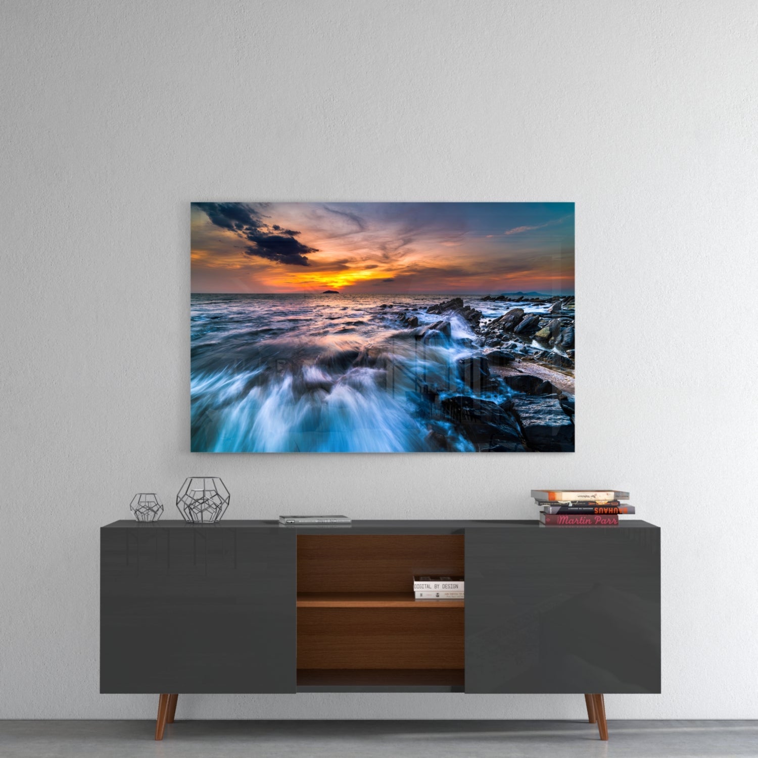 Endless Sea glass wall art displaying a rocky coastline sunset with orange sky and blue waves, mounted above a mid-century console table.