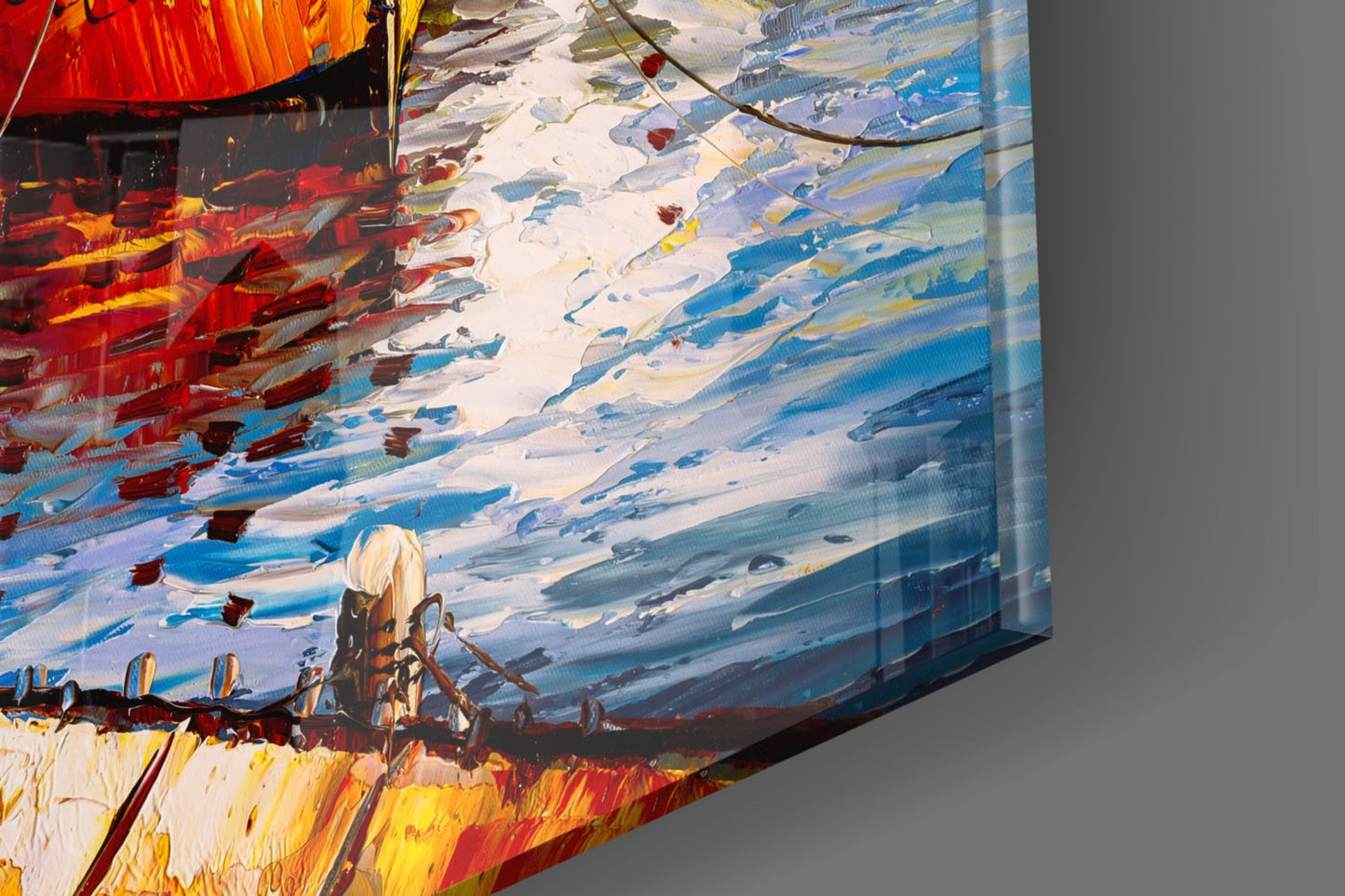 Close-up angled view of glass wall art showing painted boats in red, yellow, and blue tones with white sky and branch details.
