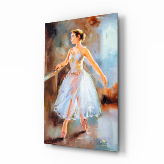 Angled view of glass wall art depicting a ballerina in white tutu gazing right, mounted on white background showing depth and shadow.