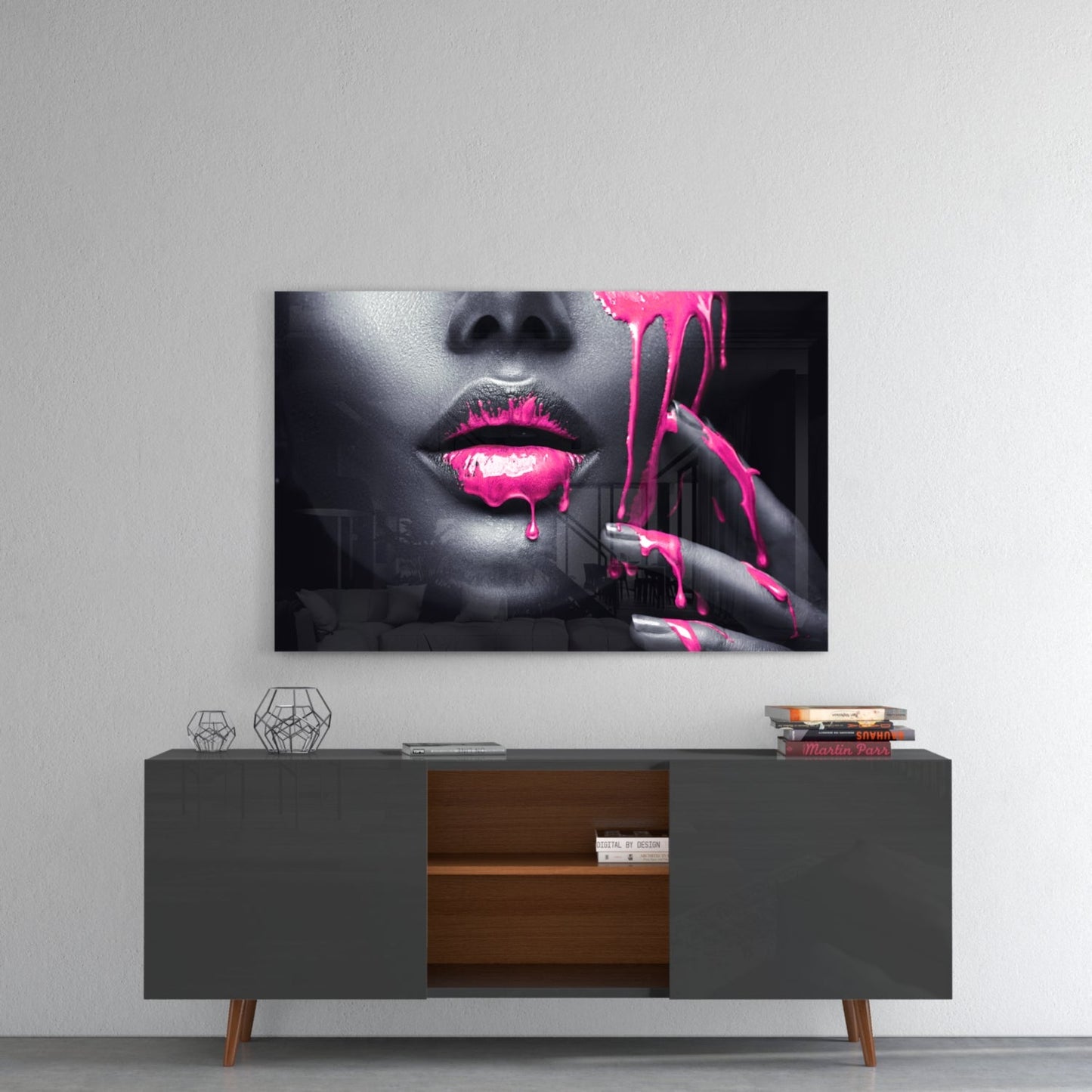 Glass wall art featuring black and white portrait with neon pink painted lips and dripping paint effect, displayed above mid-century modern sideboard.