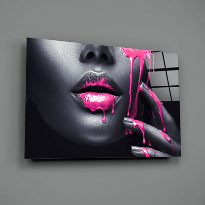 Glass wall art displaying close-up of woman's face with grayscale skin and vibrant magenta paint dripping from lips and fingers.