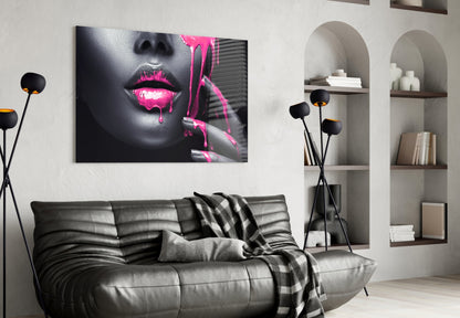 Black and gray portrait with hot pink neon lips and paint drips displayed above gray leather sofa in modern living room.