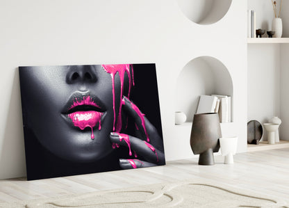 Pink Painted Woman glass wall art leaning against white wall in minimalist interior with decorative objects and shelving.