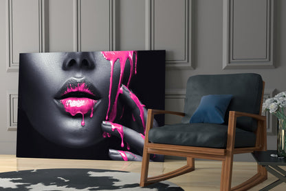 Glass wall art featuring a woman's face with bright pink dripping paint effect displayed in a modern living room setting.