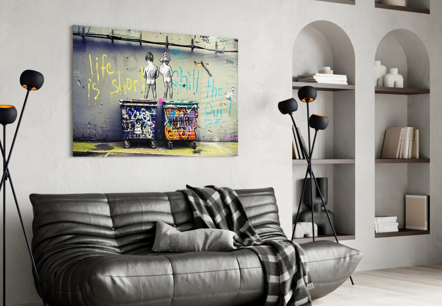 Street art glass wall panel featuring two figures and colorful graffiti with yellow "life is short" text, displayed above black leather sofa.