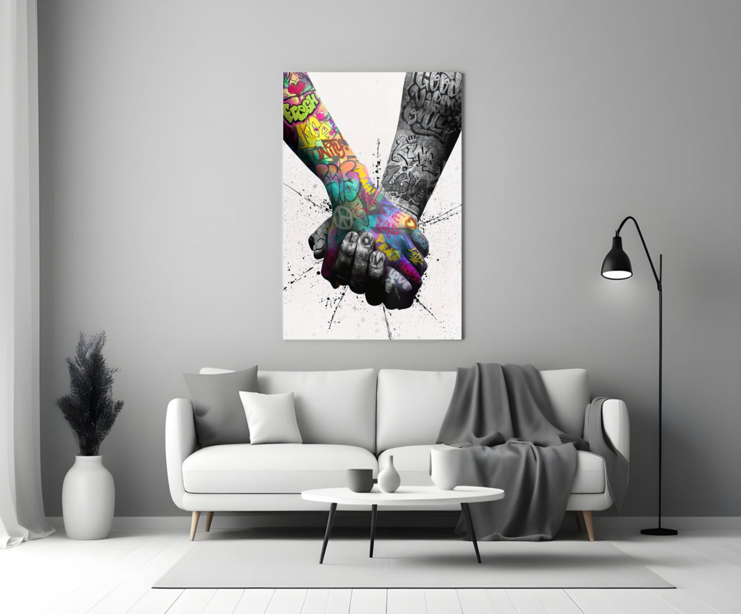 Colorful glass wall art depicting two tattooed hands holding together displayed above a white sofa in a minimalist living room.