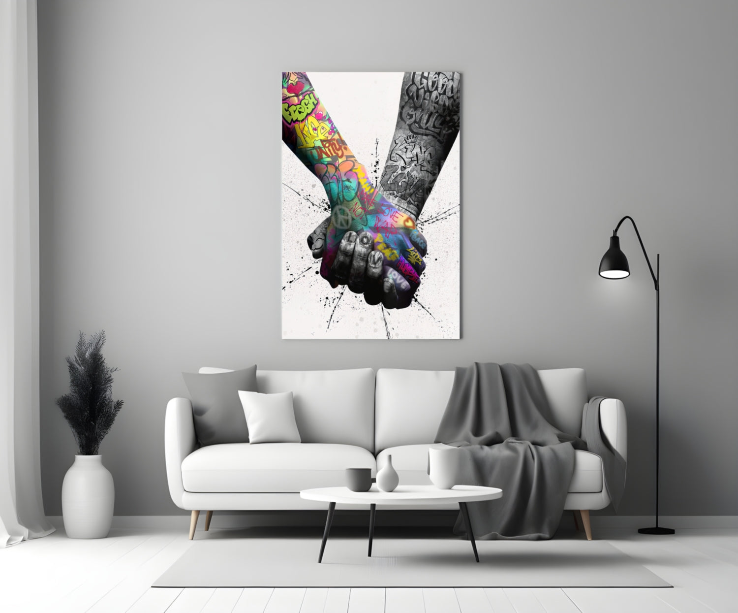 Colorful glass wall art depicting two tattooed hands holding together displayed above a white sofa in a minimalist living room.