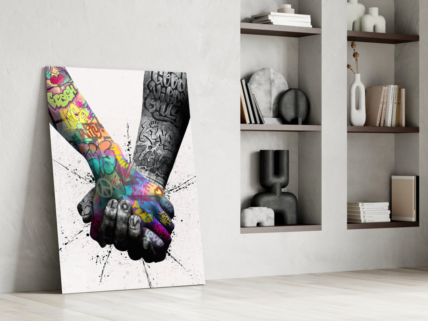 Canvas leaning against wall displaying colorful graffiti-filled peace hand gesture with black ink splatter effect, styled interior setting with shelving.