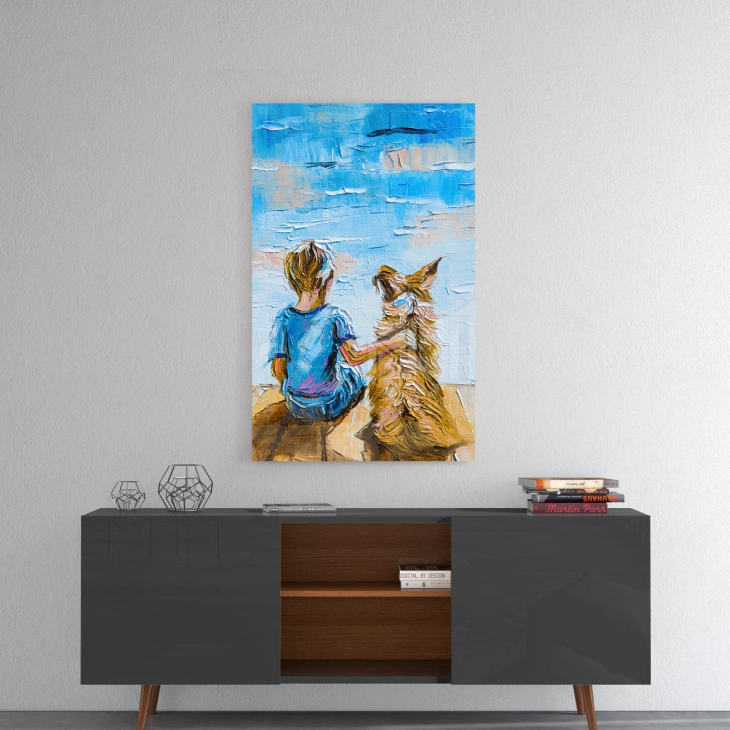 Glass wall art depicting a child in blue shirt sitting with a golden dog against a blue sky, displayed above a mid-century modern console table.