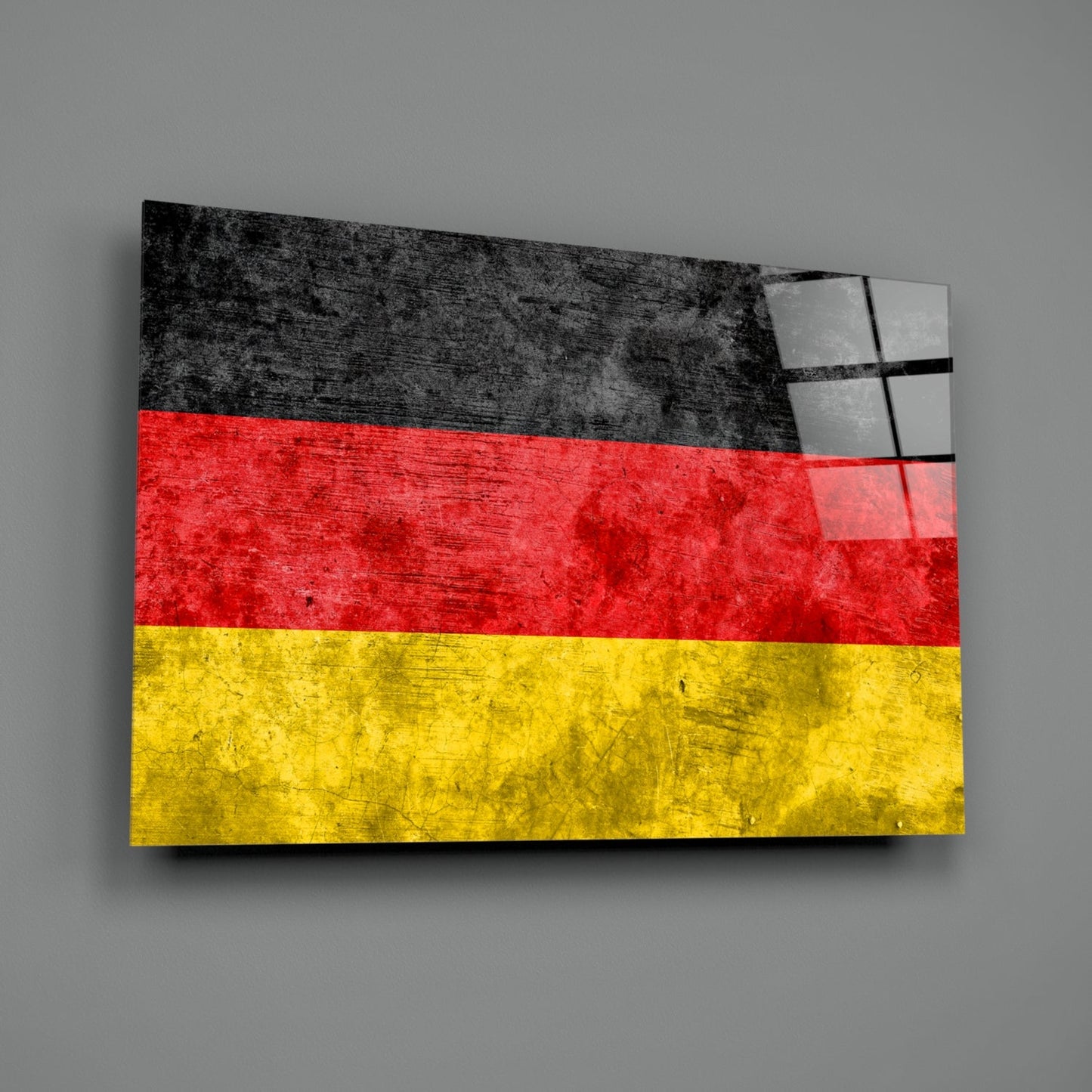 German flag glass wall art with black, red, and yellow horizontal stripes, displayed at an angle against gray background.