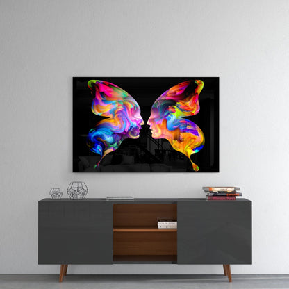 Colorful glass wall art with two vibrantly painted butterfly silhouettes displayed above a mid-century modern console table in a minimalist interior.