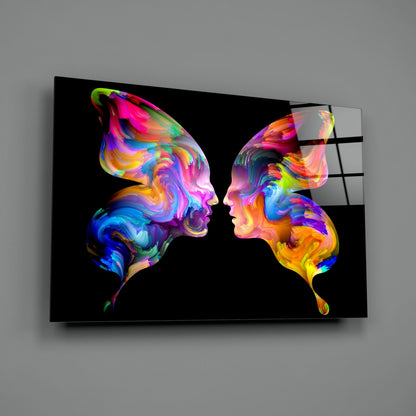 Two colorful neon profile heads facing each other on black glass wall art with vibrant rainbow gradients.
