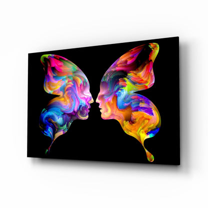 Two colorful silhouetted profiles facing each other on black glass with vibrant rainbow paint swirl patterns.