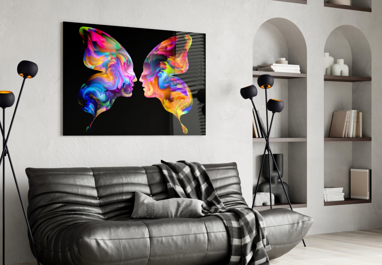 Colorful neon butterfly silhouettes glass art hanging above gray leather sofa in modern living room with white shelving.