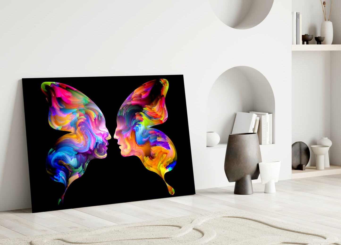 Vibrant rainbow glass art featuring two colorful butterfly silhouettes facing each other against black background, displayed on floor against white wall.