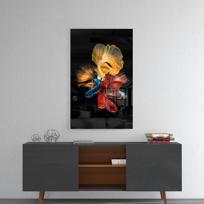 Colorful glass wall art depicting three flowing betta fish in yellow, blue, and red tones displayed above a mid-century modern console table.