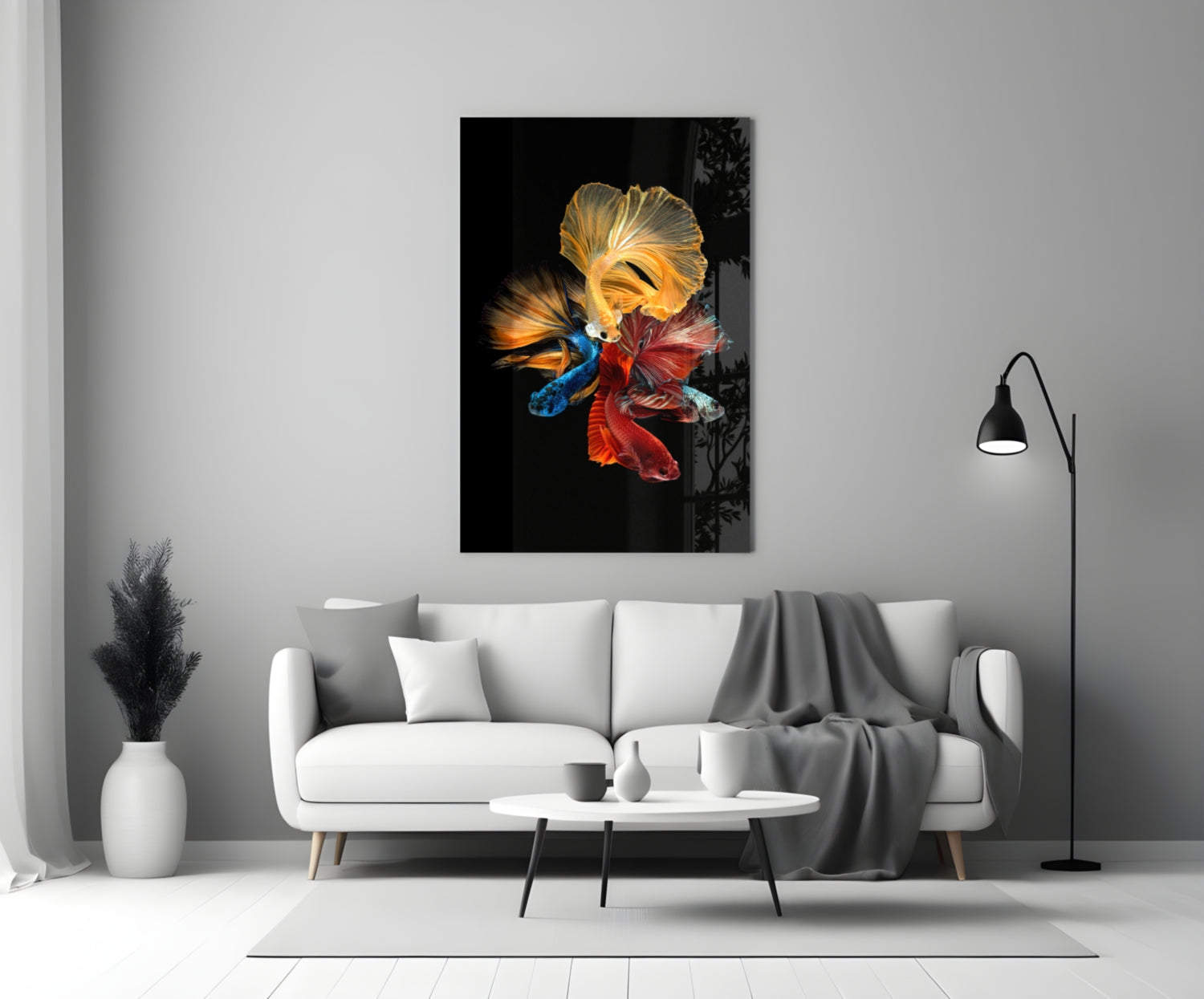 Betta's Dance glass wall art displayed above a white sofa in a minimalist living room, featuring colorful fish against black background.