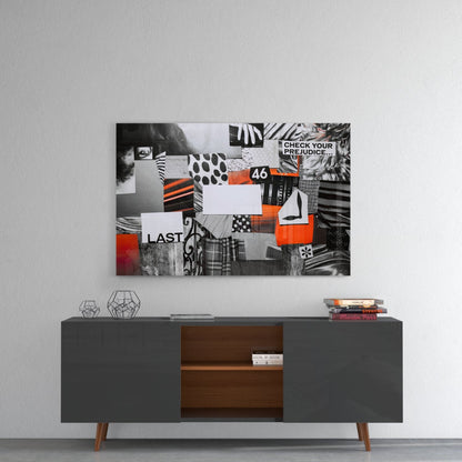 Abstract glass wall art with black, white, and orange collage patterns mounted above a mid-century modern console table.