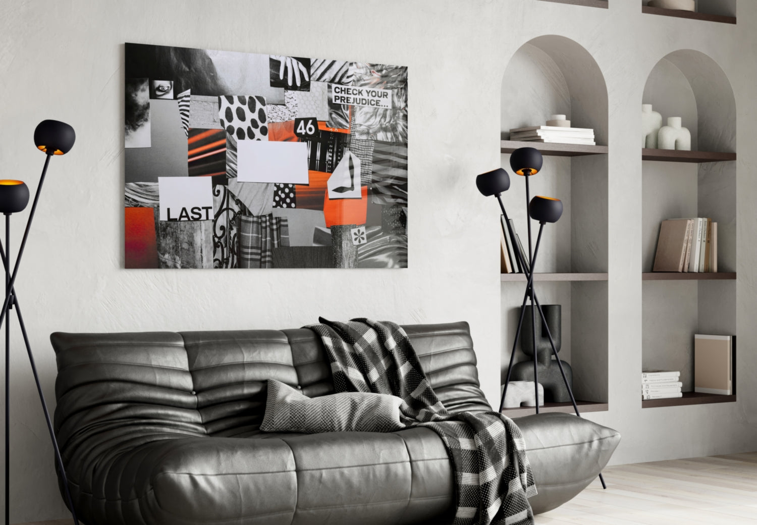 Modern living room featuring black leather sofa with gray throw blanket, black floor lamp with orange accents, and abstract mixed-media wall art with orange, black, and white collage elements above sofa.