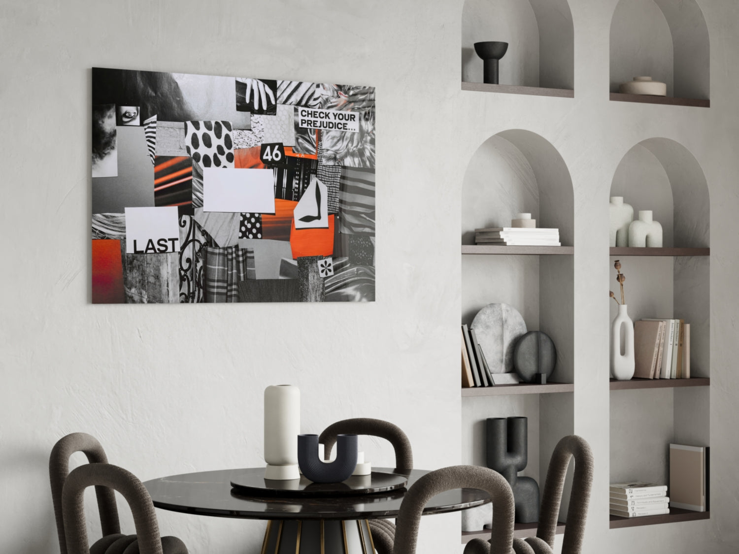 Collage-style glass wall art featuring black, white, and orange geometric patterns with text including "CHECK YOUR PREJUDICE" and "LAST" displayed above a round dining table.