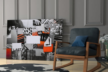 Glass wall art panel featuring black and white patchwork patterns with orange accents, displaying text "CHECK YOUR PREJUDICE," "46," and "LAST," installed in modern living room.