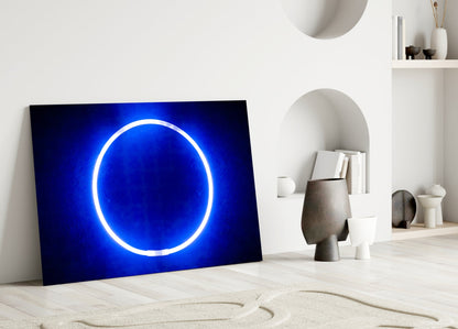 Blue Ring Glass Wall Art leaning against white wall in minimalist room with shelving and decorative objects.