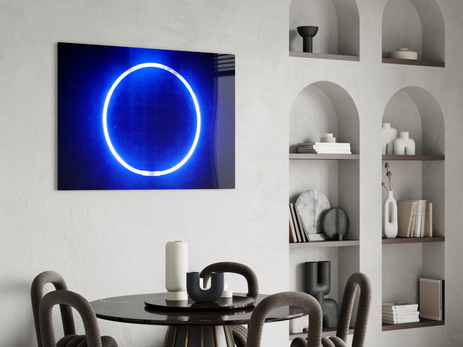 Blue neon circle glowing on dark background, mounted above round black table in modern dining room with shelving.